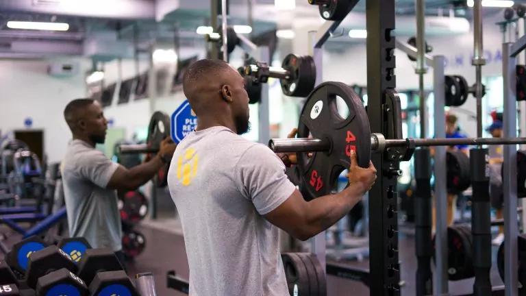 Certified Instructor Adjusting Weights at HiTONE Fitness Facility