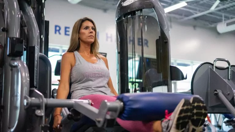 A Focused Woman Performing Legs Workout at HiTONE Fitness