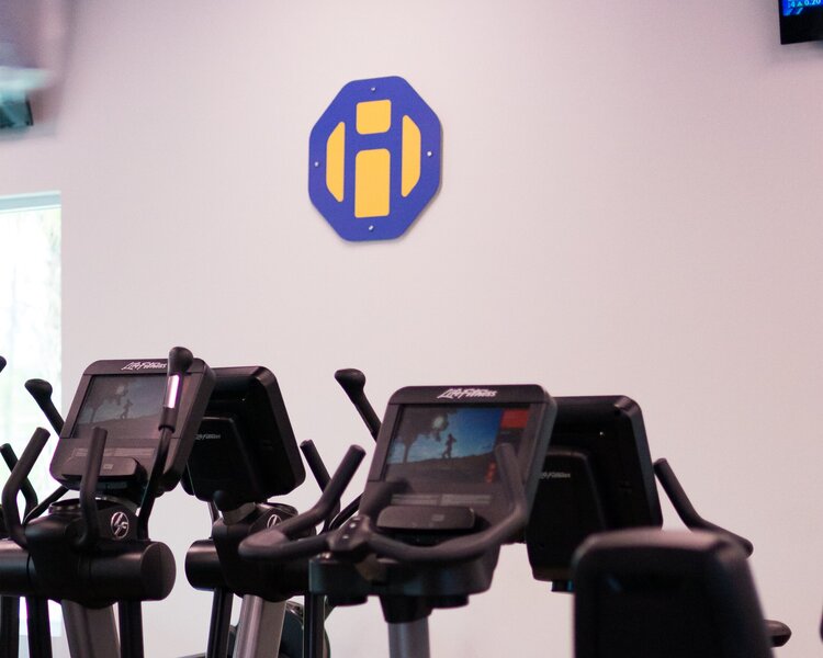 HiTONE Fitness Logo on the Wall Behind the Treadmills