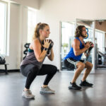 Woman and Man Working Out With Kettlebells at HiTONE Fitness Facility