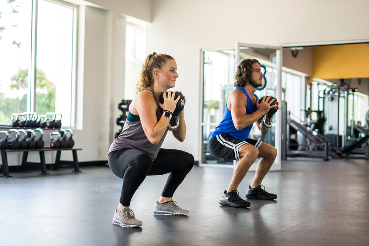 Woman and Man Working Out With Kettlebells at HiTONE Fitness Facility