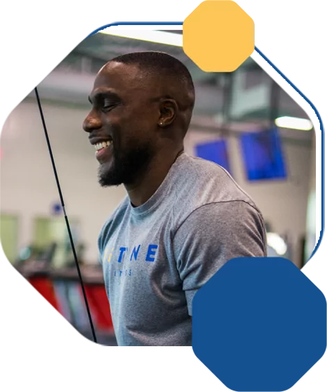 Smiling Man In Gray Shirt Working Out at HiTINE Fitness Facility