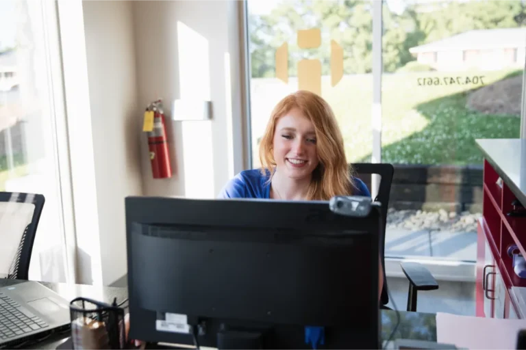 A blonde woman working on a pc.