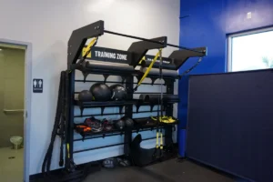 A rack with gym equipment, next to a toilet entrance.
