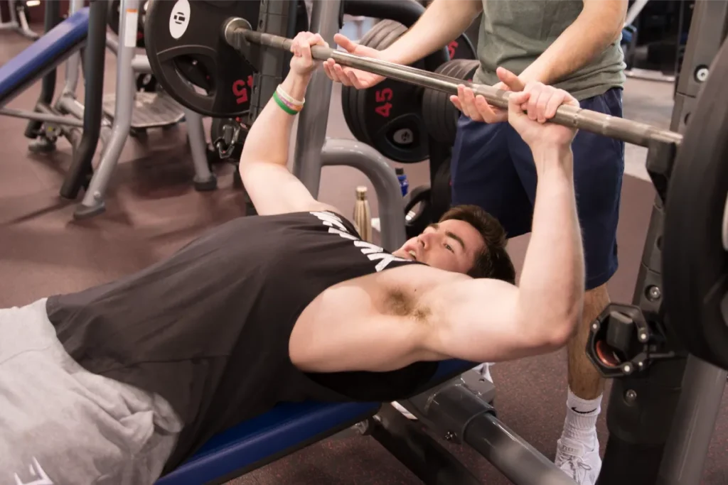 Man in black shirt working out on a bench.