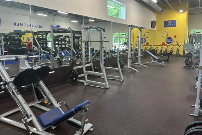 Various exercise equipment in front of a mirror at a gym.