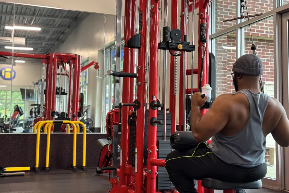 A man doing the seated lat pulldown exercise on the high pulley machine.