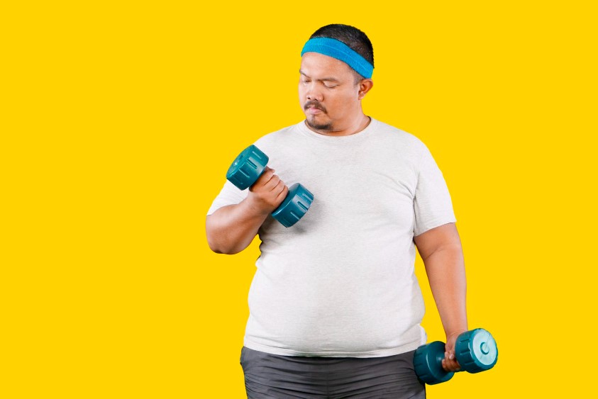 An obese man in a white t-shirt and blue headband lifts a small dumbbell. Yellow background.