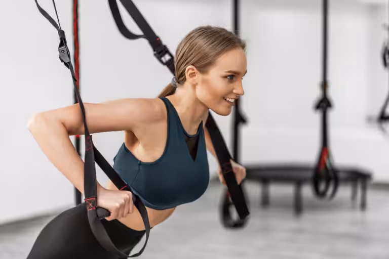 Woman exercising with fitness suspension straps