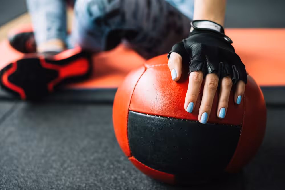 Gloved hand on a red medicine ball