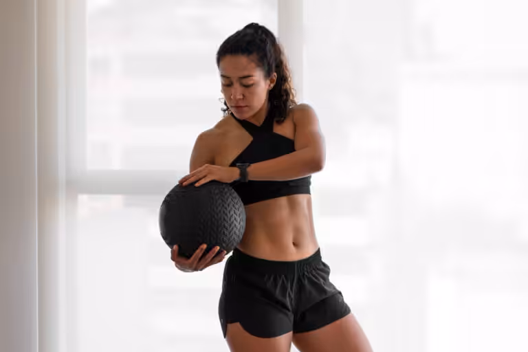Woman holding exercise ball indoors.