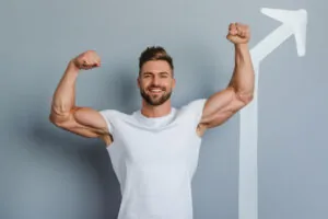 Smiling man flexing muscles points to arrow