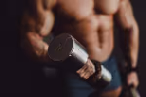 Muscular person lifting a 10kg dumbbell.