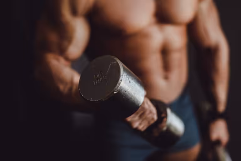 Muscular person lifting a 10kg dumbbell.