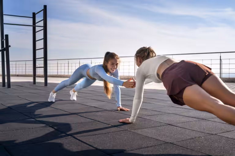 Women doing outdoor partner workout.