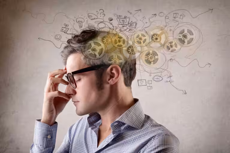 Man thinking, gears and ideas drawn above head.