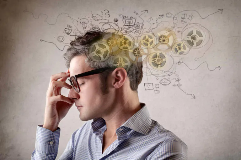 Man thinking, gears and ideas drawn above head.