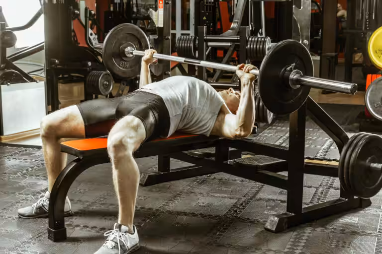 Man bench pressing barbell in gym