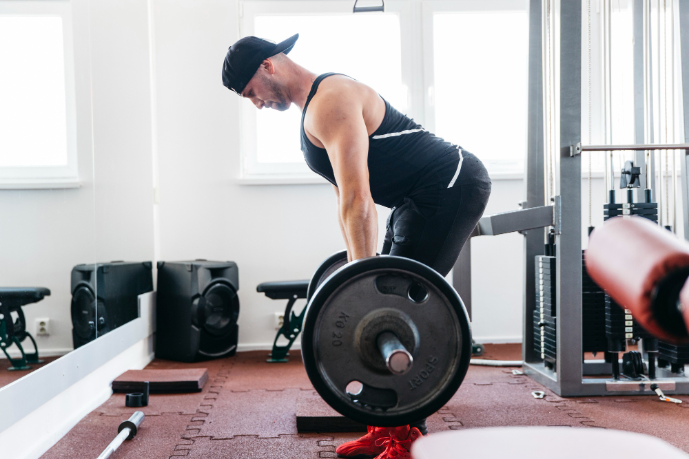 Man performing barbell deadlift in gym
