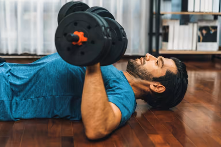 Man doing dumbbell chest press on floor