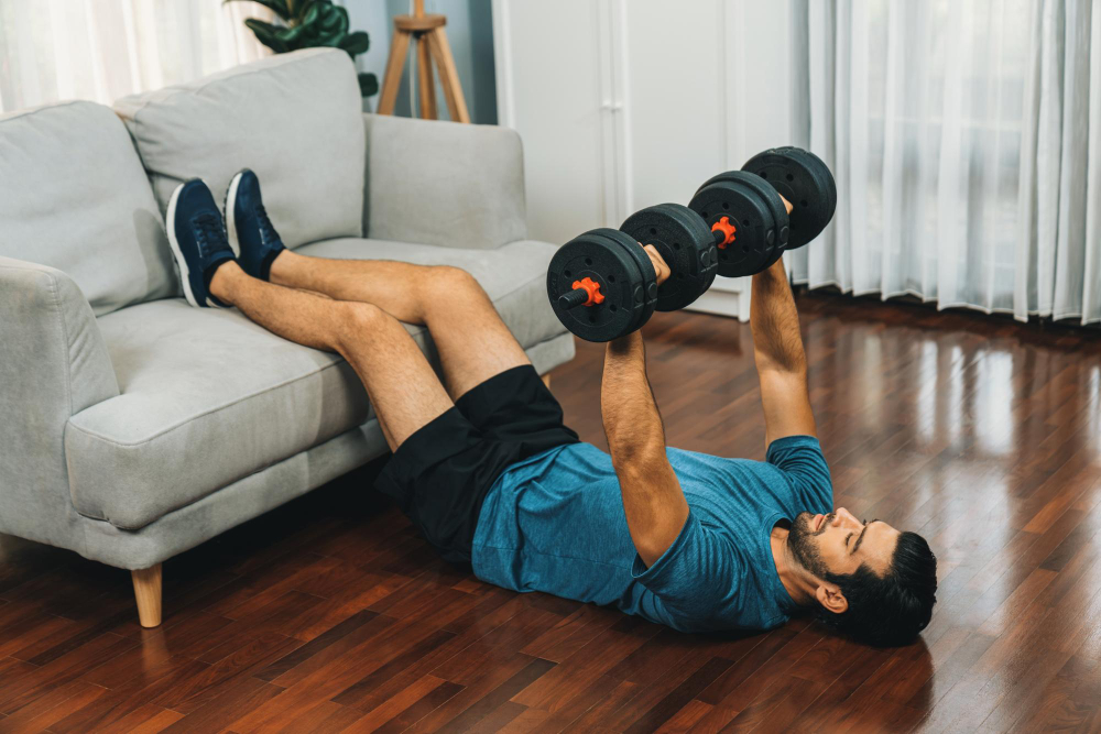 Man exercising with dumbbells on floor