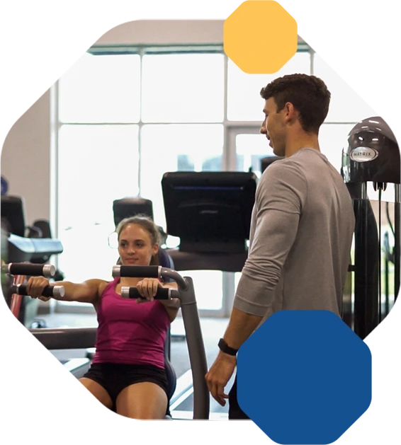 Woman exercising with trainer in a gym