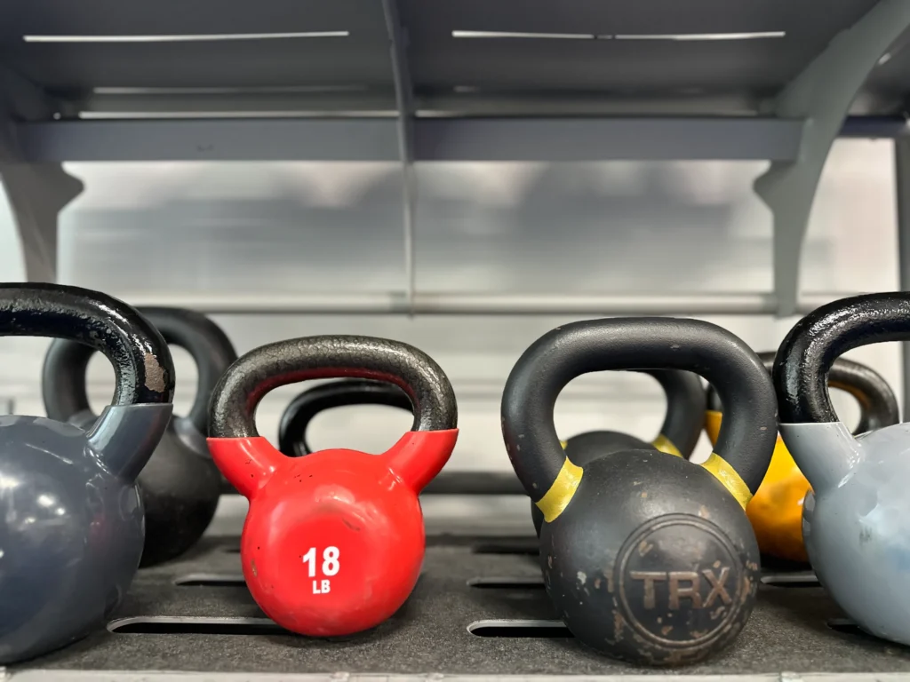 Kettlebells on gym rack including red 18-pound weight