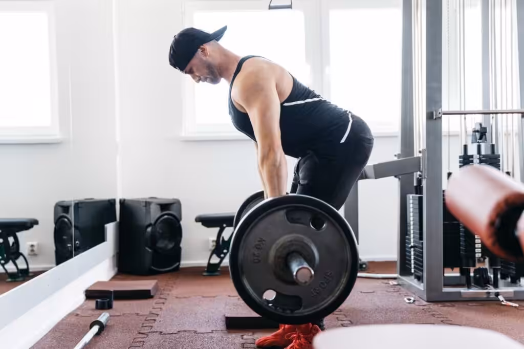 Man performing barbell deadlift in gym
