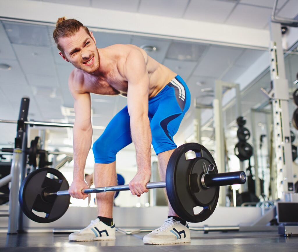Man performing deadlift with barbell in gym