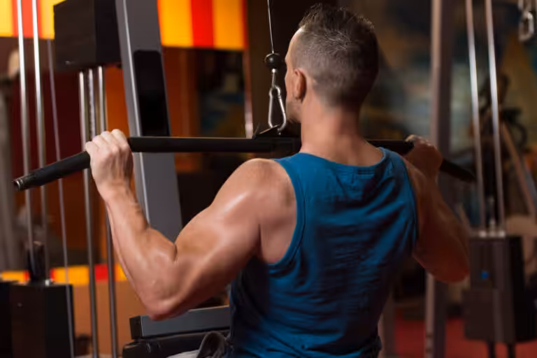 Man performing lat pulldown exercise at gym machine